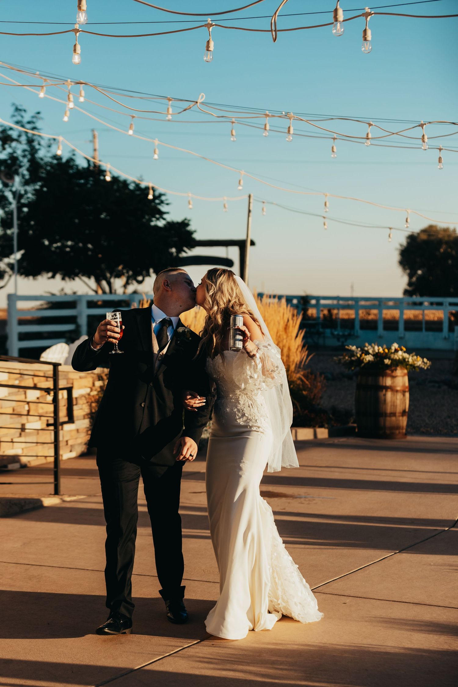 Wedding celebration under string lights at sunset on an outdoor patio.
