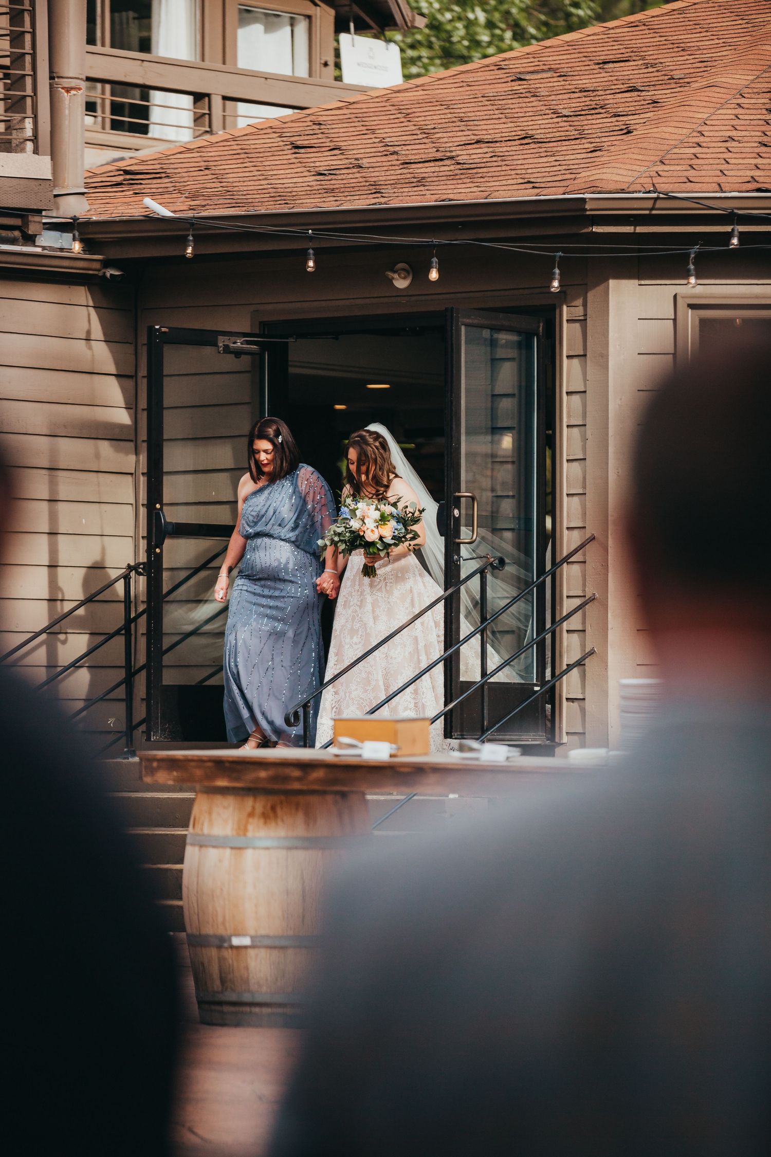 Wedding party enters rustic venue with wine barrel decor.