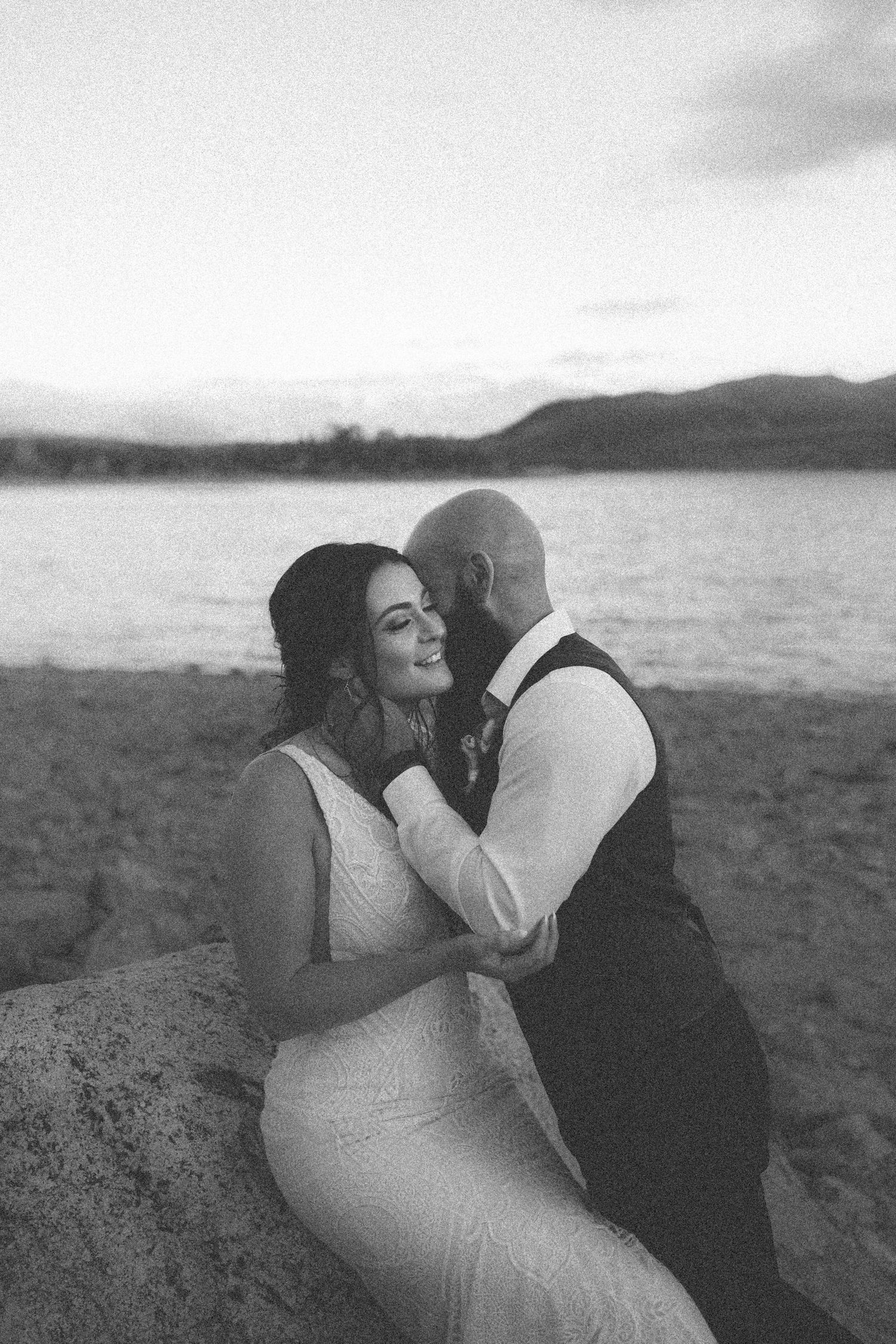 Black and white wedding portrait by serene lakeside.
