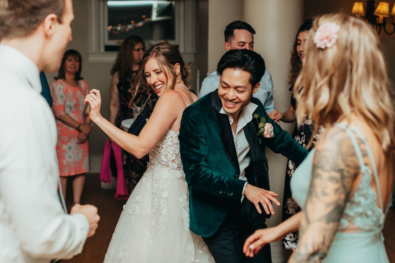Wedding party dances together at a reception with joyful expressions.