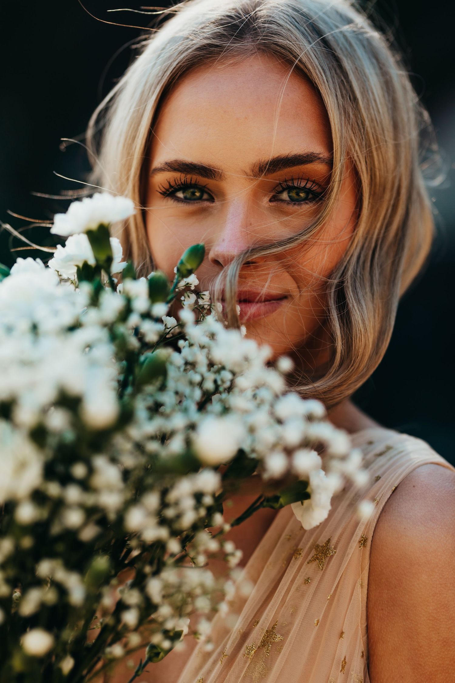 Close-up portrait with white flowers creating a dreamy romantic effect.