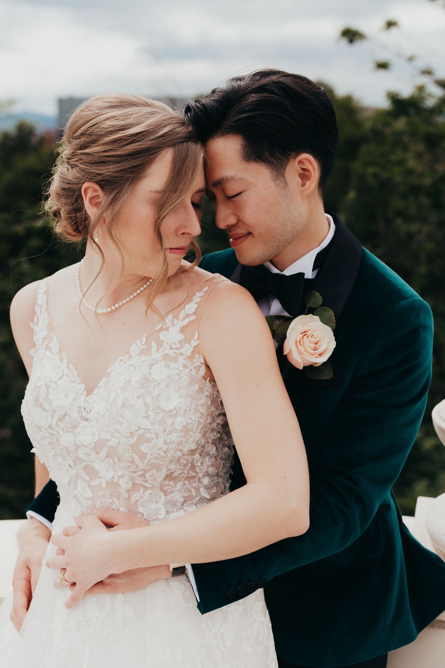 A romantic wedding moment captured on a balcony with the couple in formal attire.