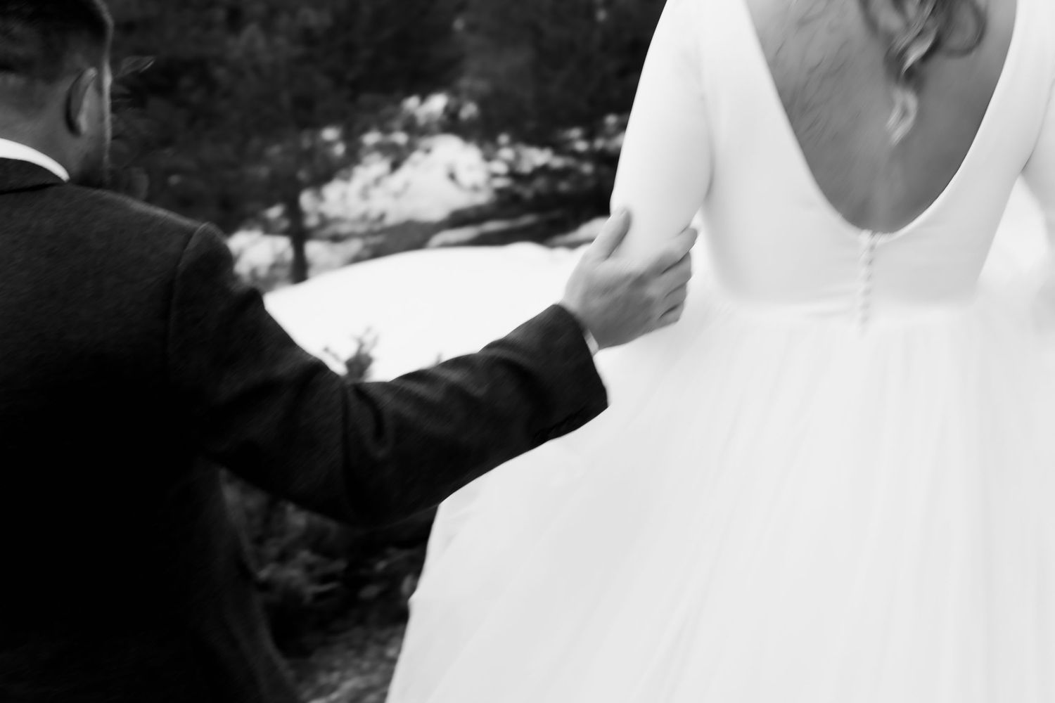 Black and white detail shot of wedding dress and gentle touch.