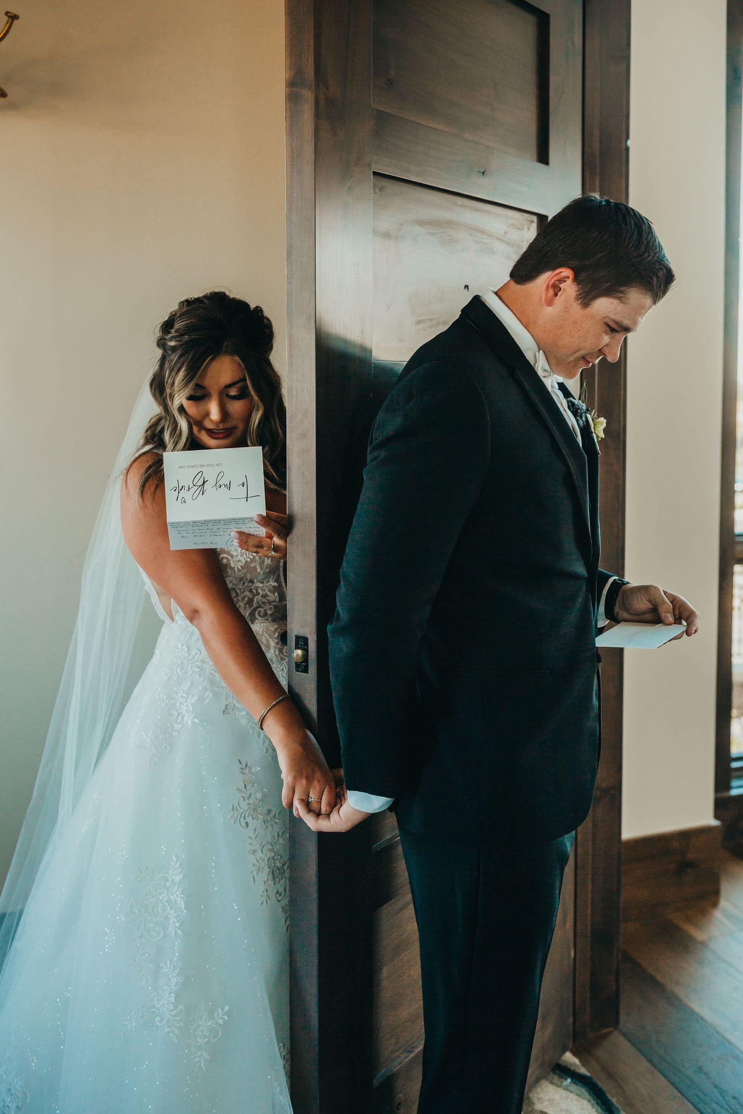 First look moment between bride and groom standing back to back before their wedding ceremony.