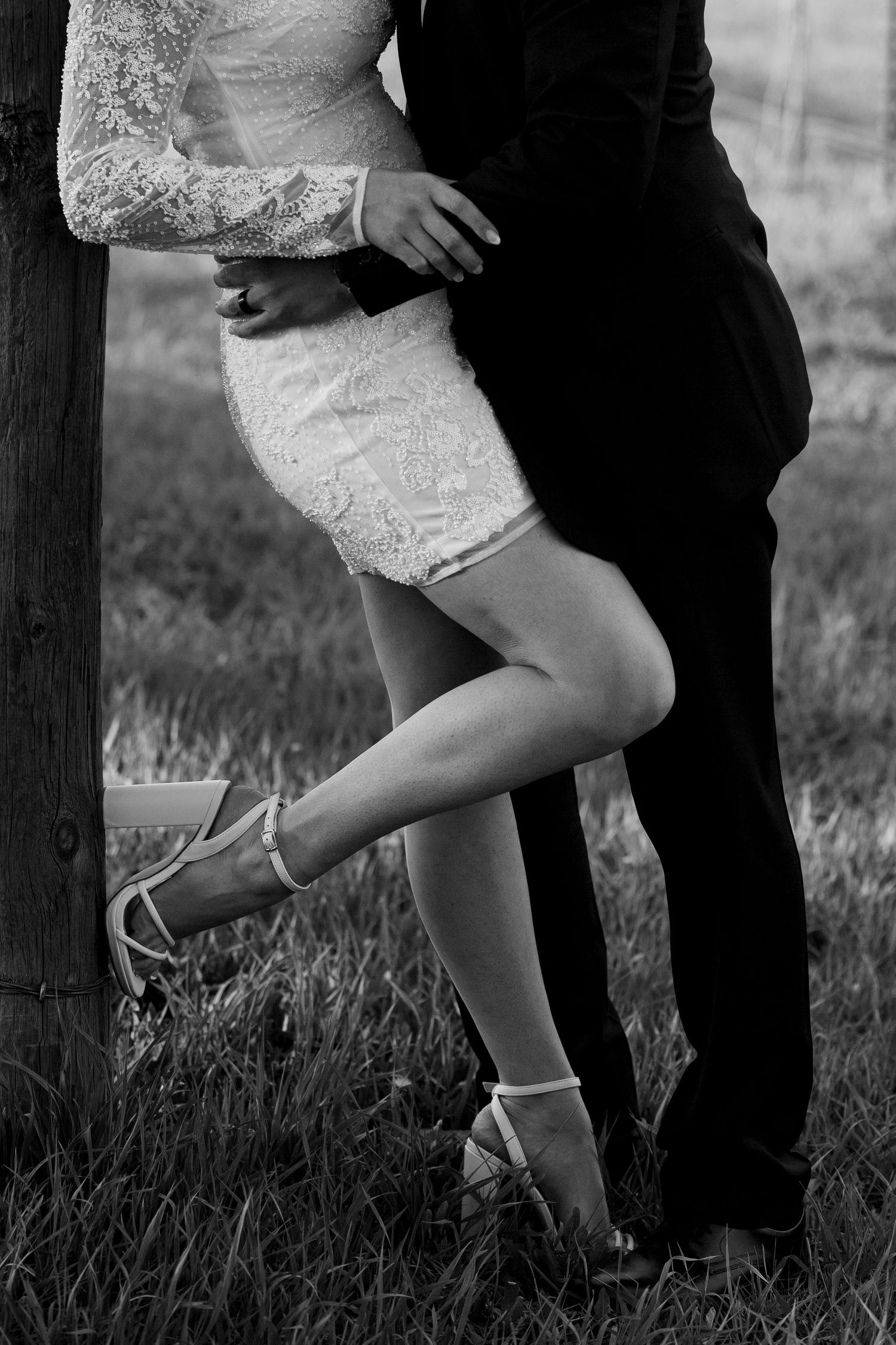Black and white photo showing elegant footwear and dress details during an intimate moment.