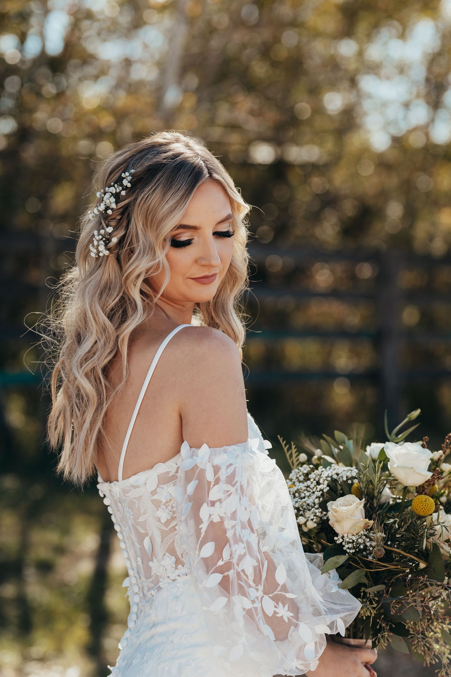Elegant bridal portrait featuring lace dress and floral bouquet in golden afternoon light.
