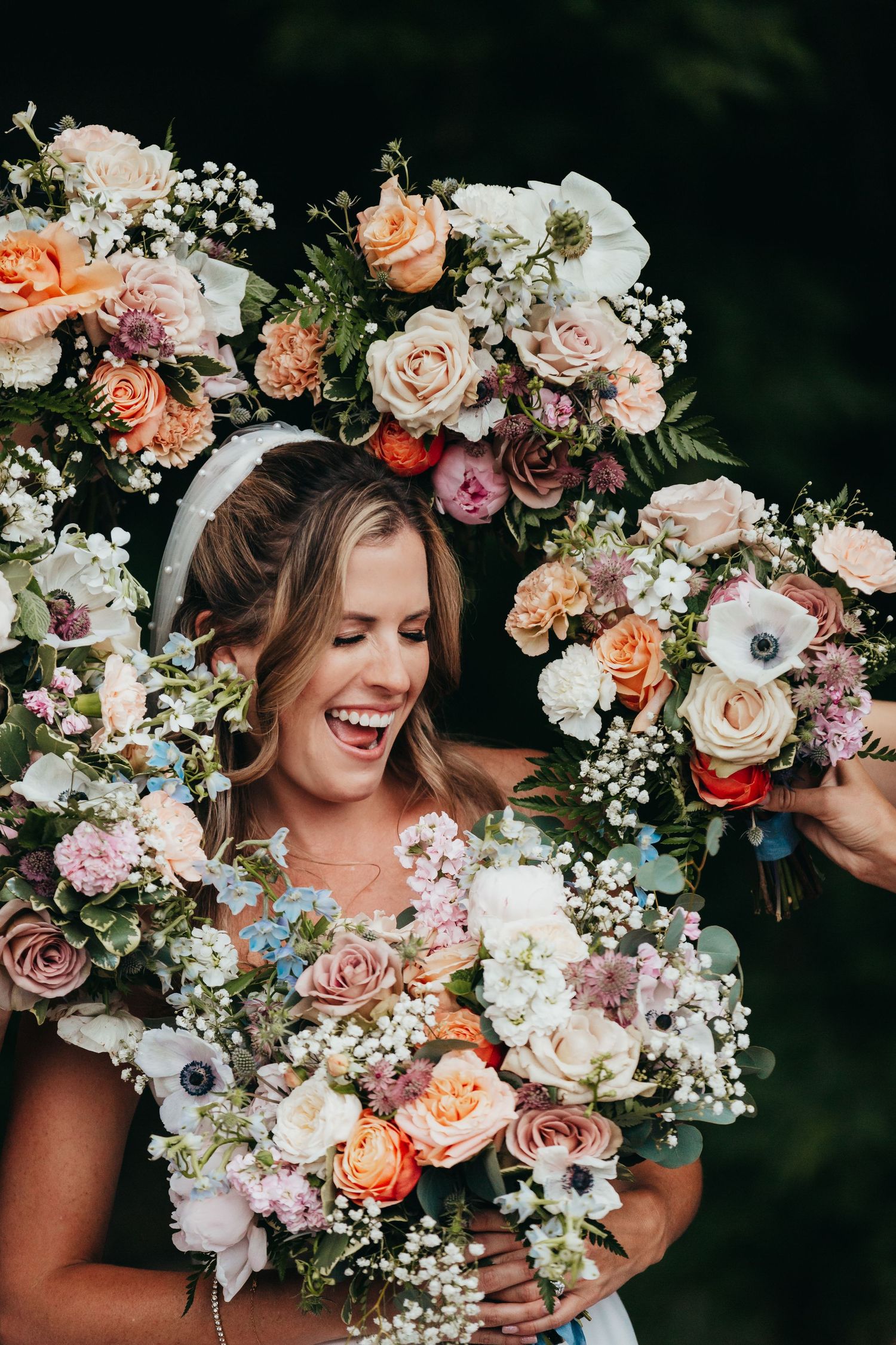 Joyful moment with abundant floral arrangements featuring peach and pink roses with baby's breath.