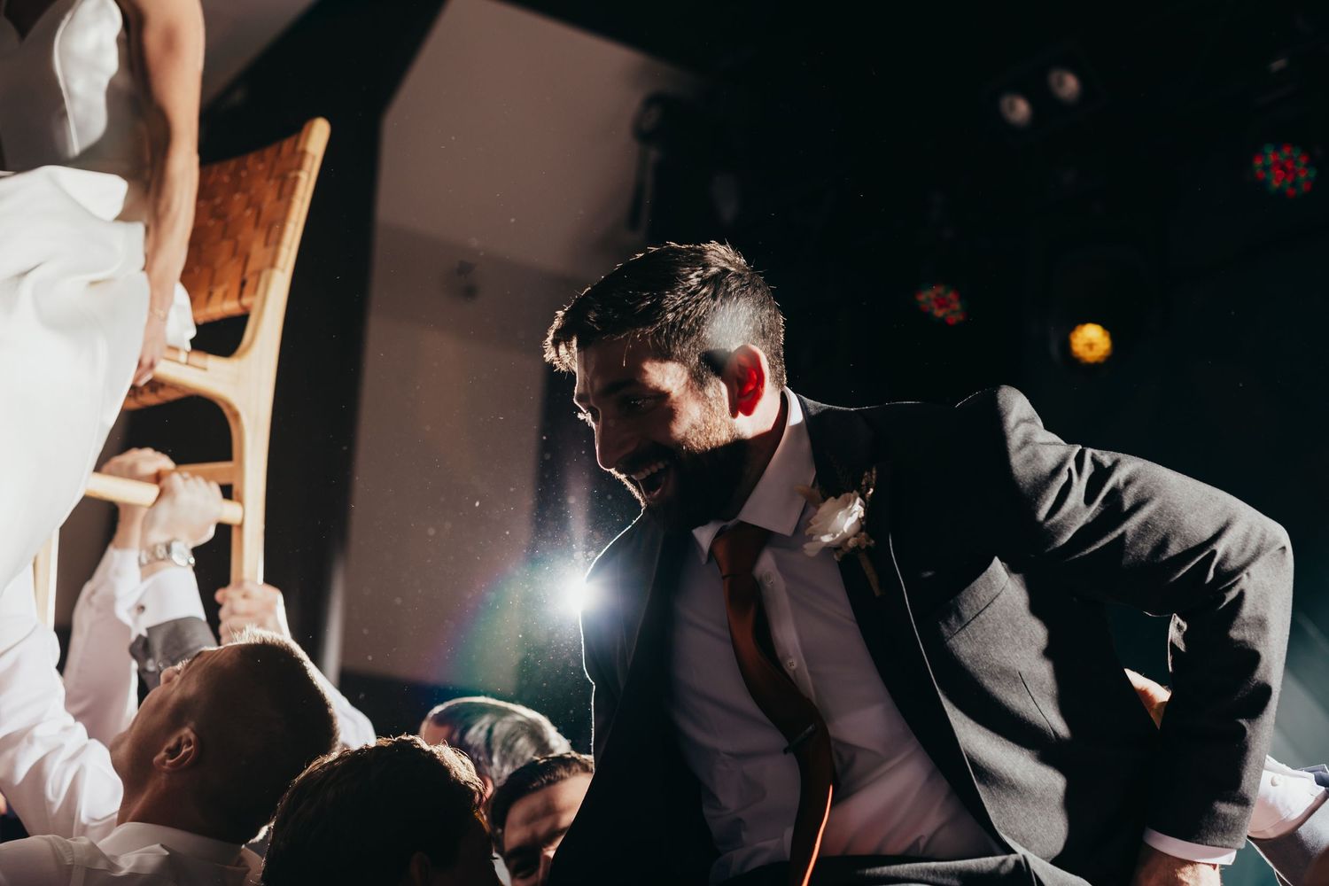 Energetic wedding reception with dramatic lighting and dancing guests.