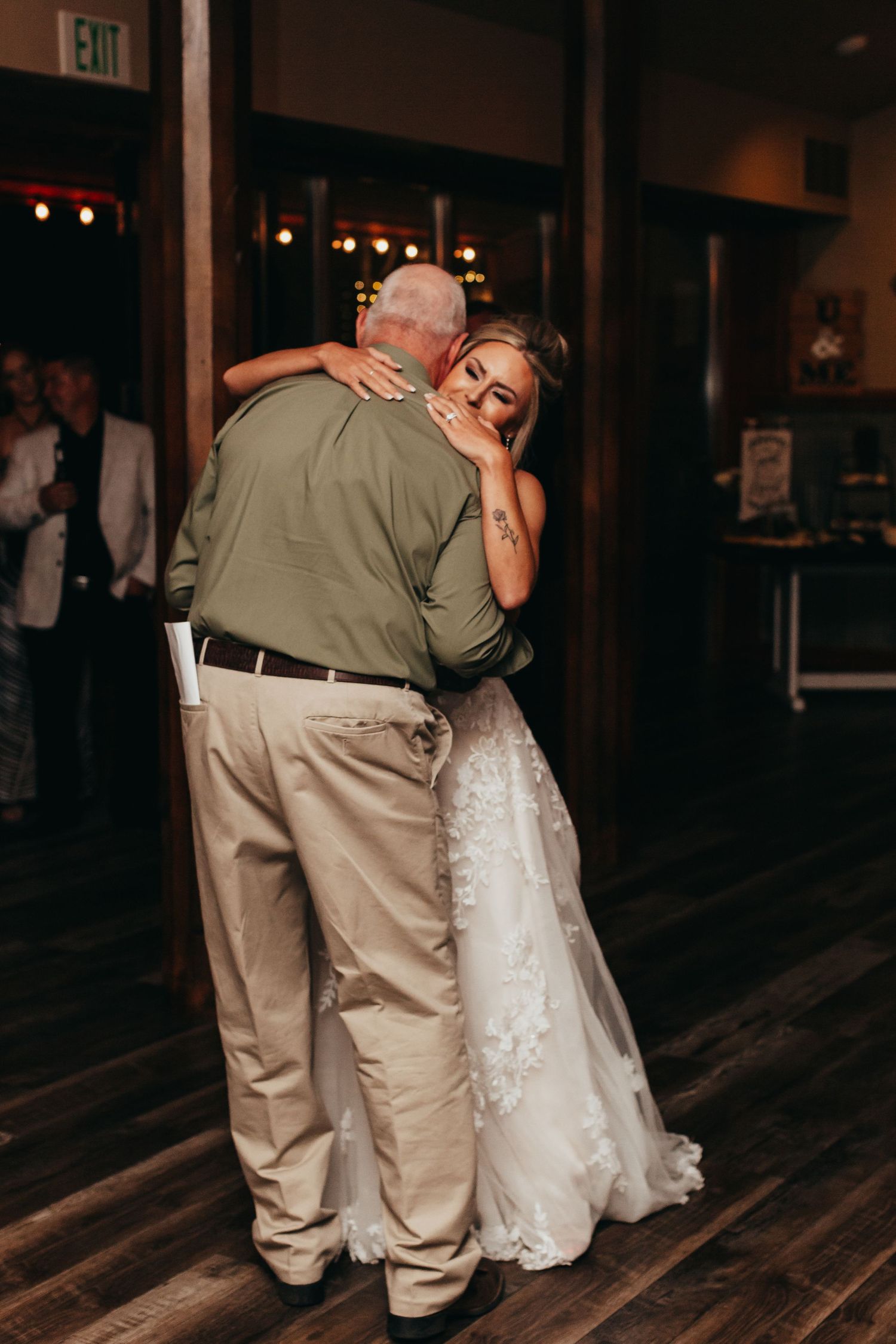 Tender dance moment on wooden floor during wedding reception.