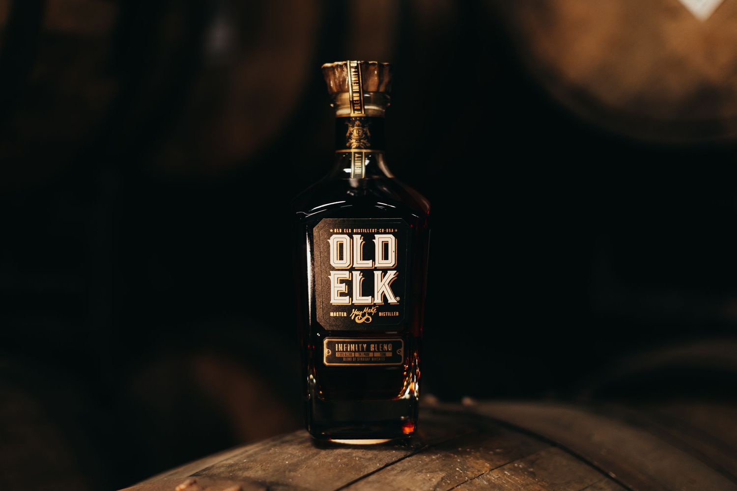 Bottle of Old Elk bourbon whiskey photographed in moody lighting.