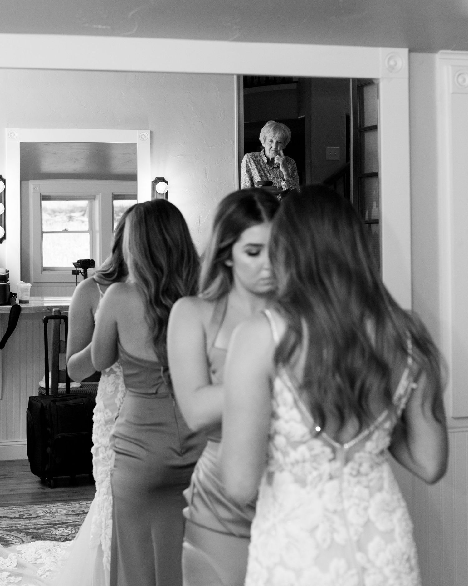 Black and white photo of wedding preparation moments in a getting ready room.