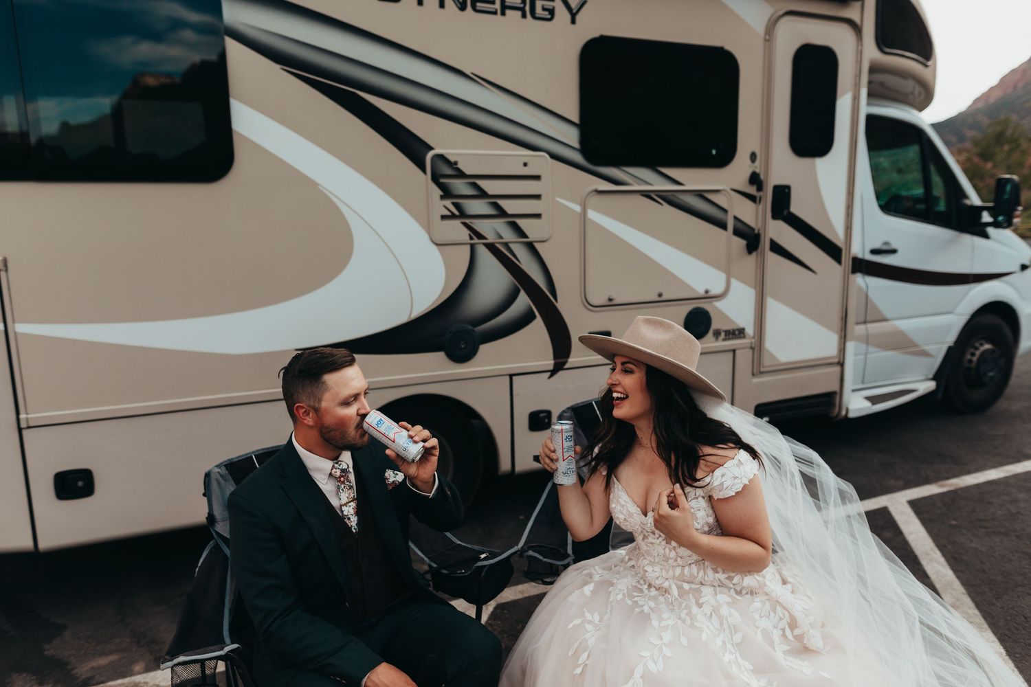 Wedding couple shares drinks outside their RV camper during adventure elopement.
