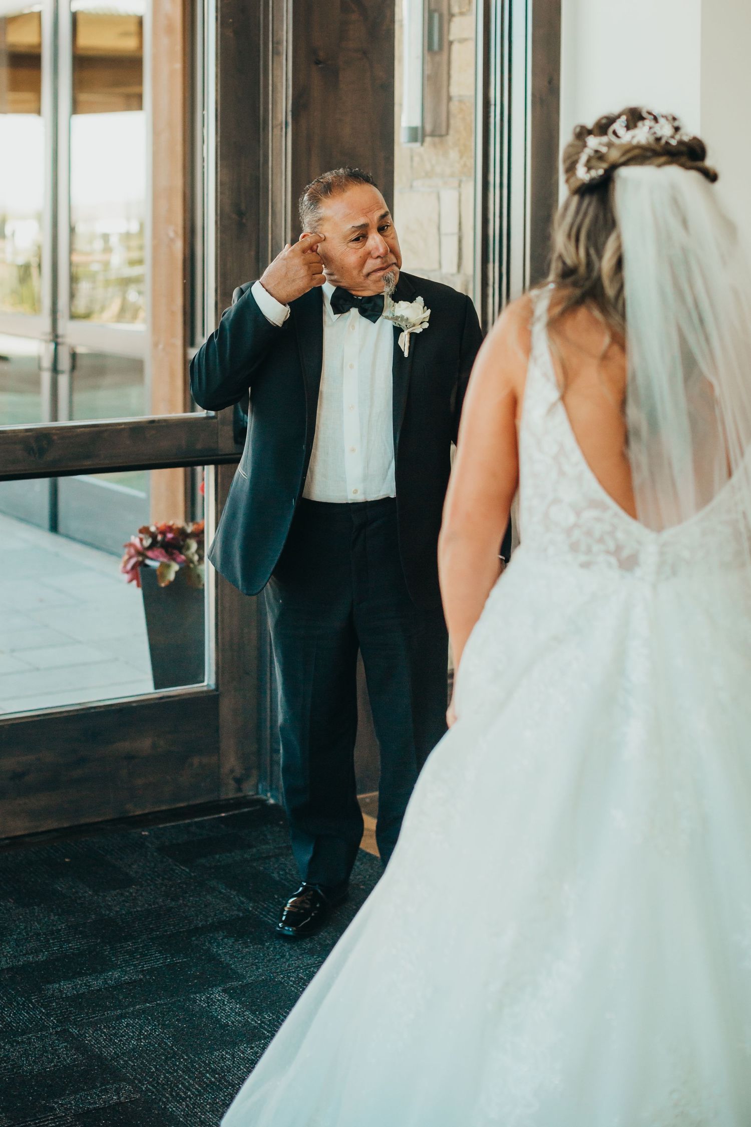 Emotional first look reaction during wedding as bride shows her dress.