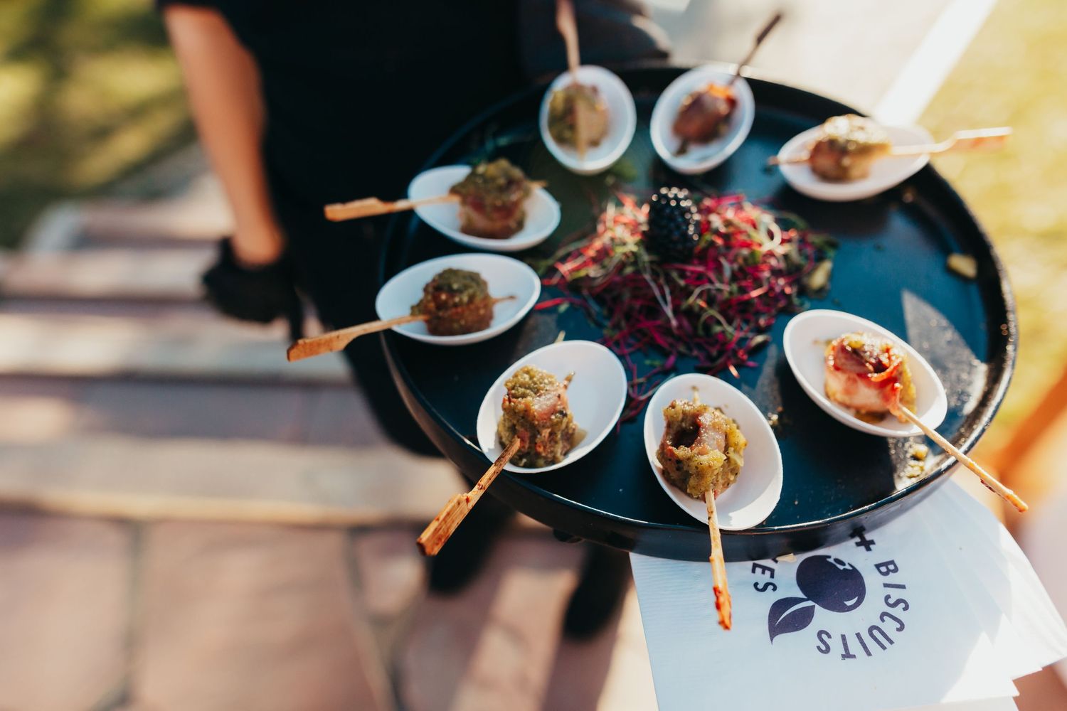 An elegant tray of appetizer bites served on small white plates during a catered event.