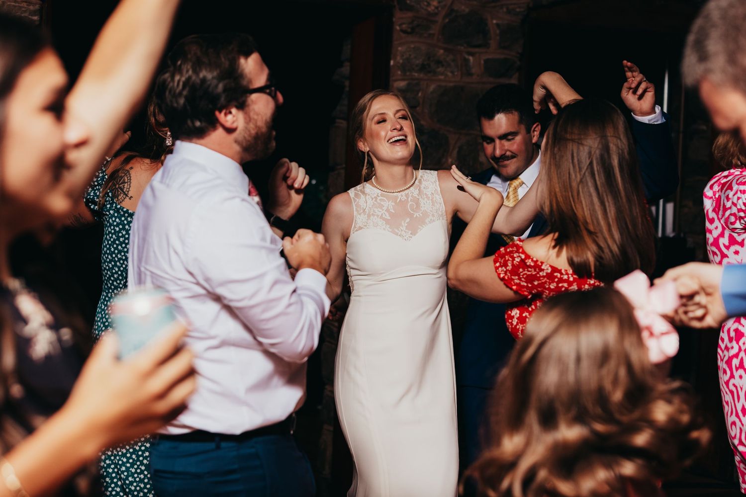 Lively wedding reception dance floor scene with celebratory guests.