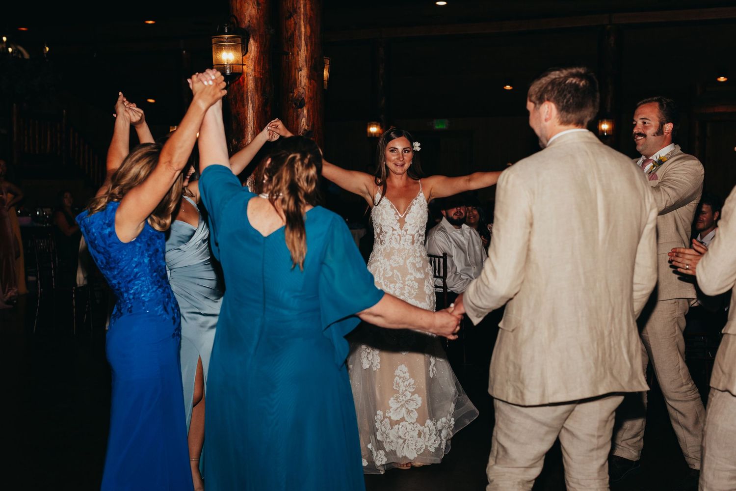 Wedding guests dancing and celebrating together on the dance floor at an evening reception.
