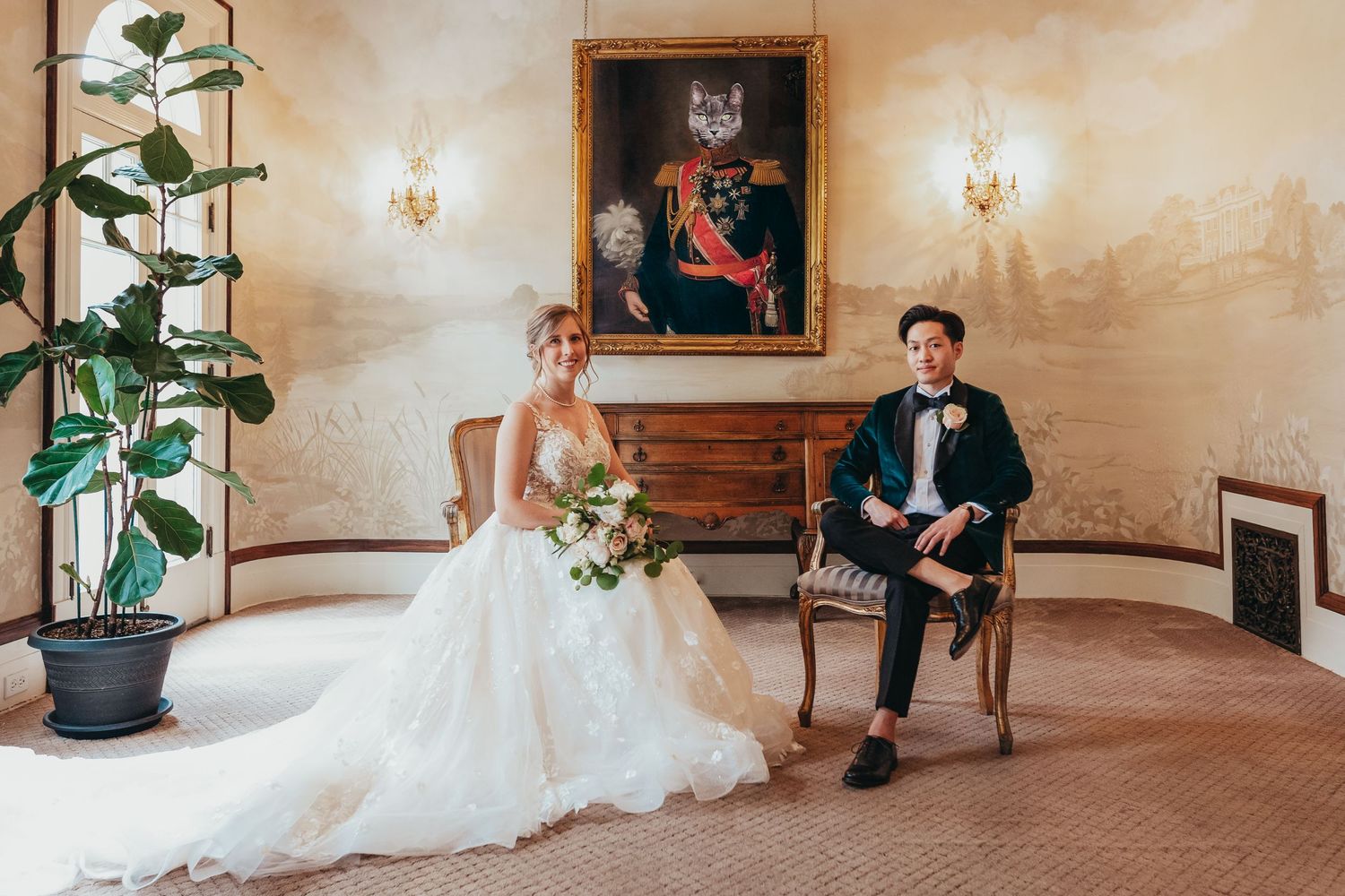 A wedding couple poses formally in an elegant room with vintage decor and potted plants.