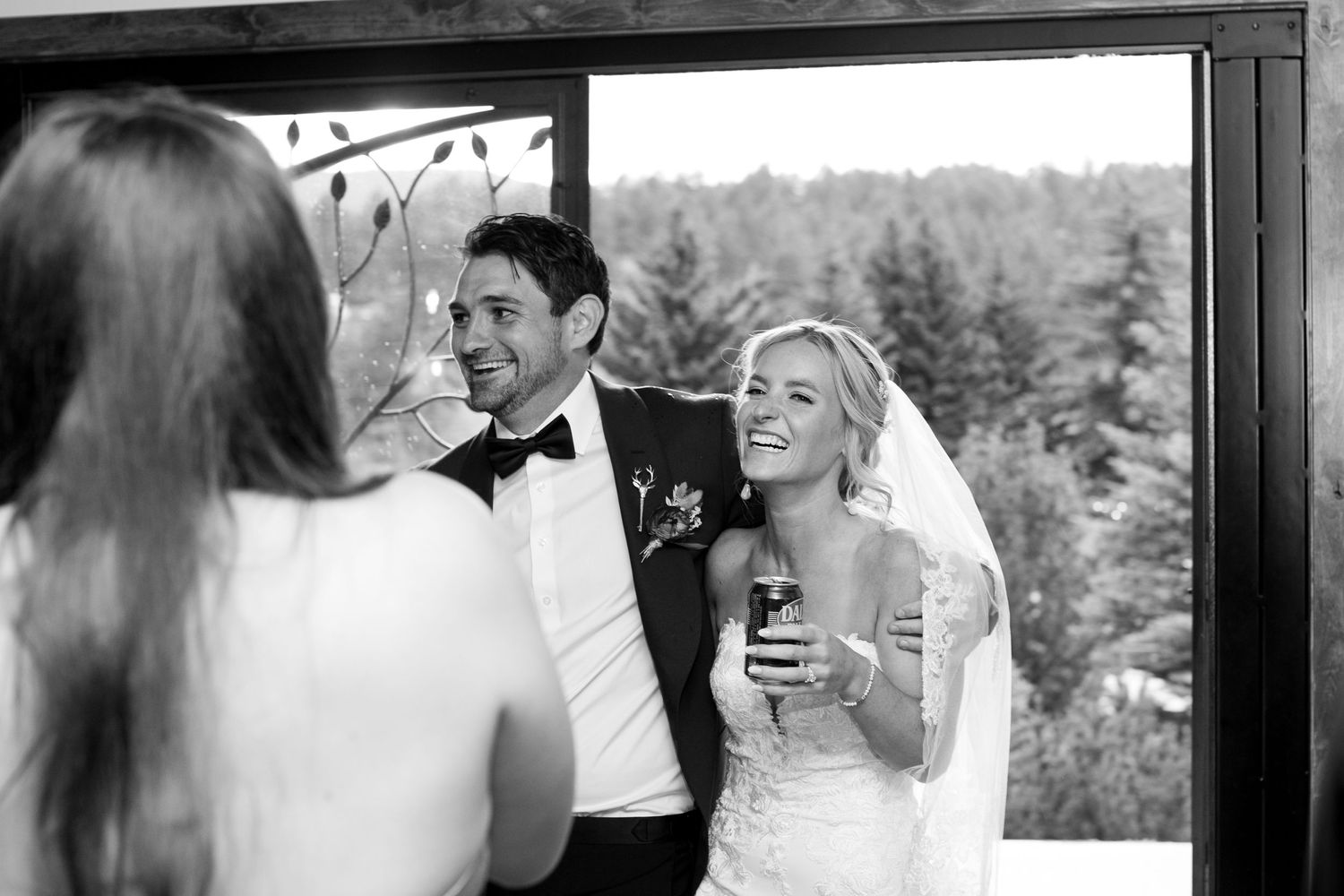 Black and white candid reception photo showing joyful laughter and celebration.