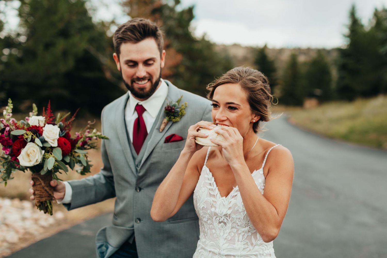 Newlyweds share a snack break on a country road after their ceremony.