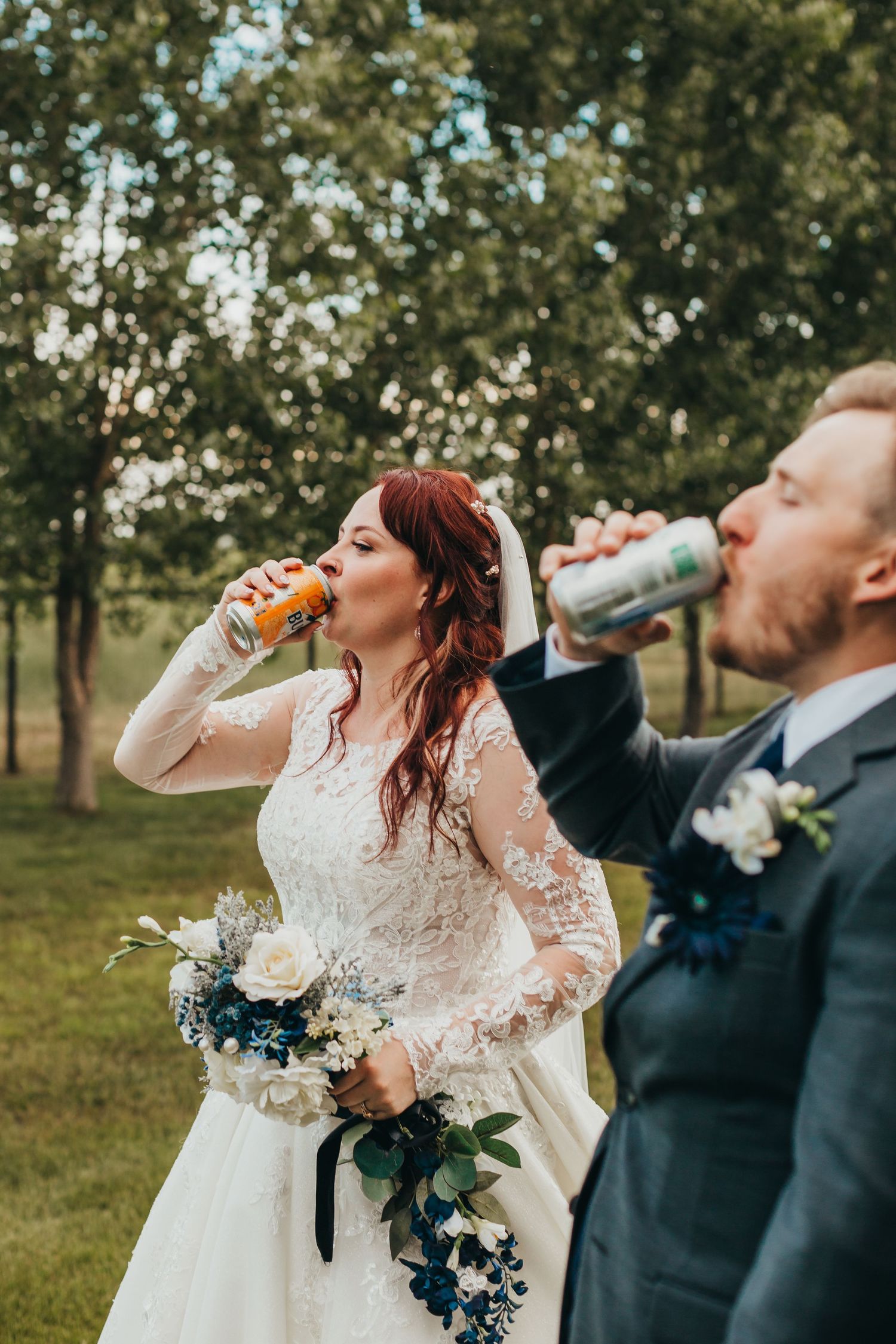 Couple enjoying beverages together while holding wedding bouquet with blue and white flowers.