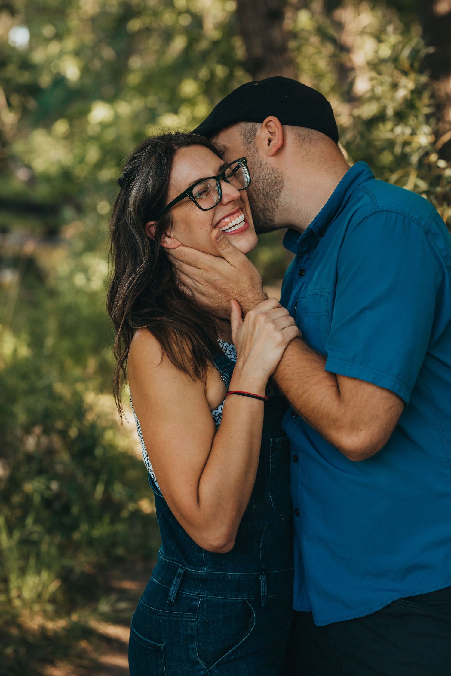 Candid couple sharing joyful moment together outdoors in natural lighting.