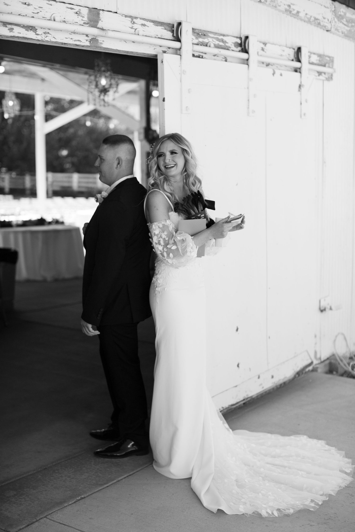 Romantic first look moment in black and white at rustic venue.