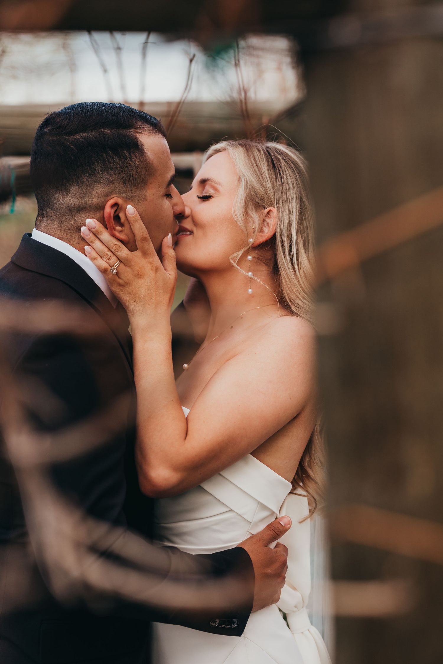 Intimate moment between newlyweds captured through creative framing and soft focus.