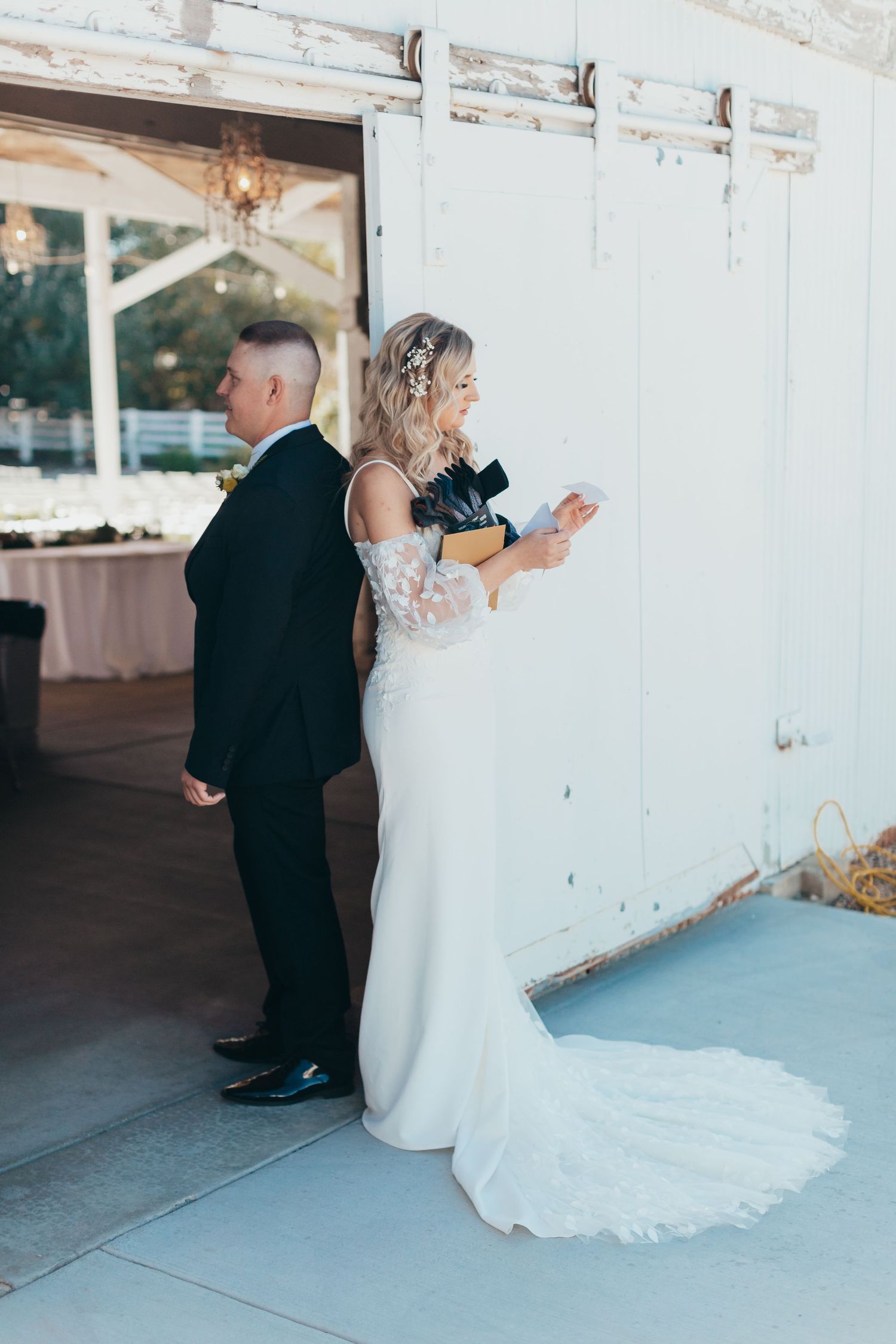 Bride and groom doing first look wedding photo while facing opposite directions.