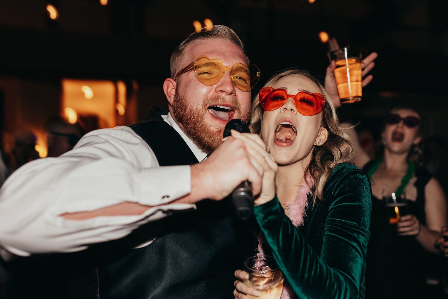 Party guests having fun and singing together at evening celebration.