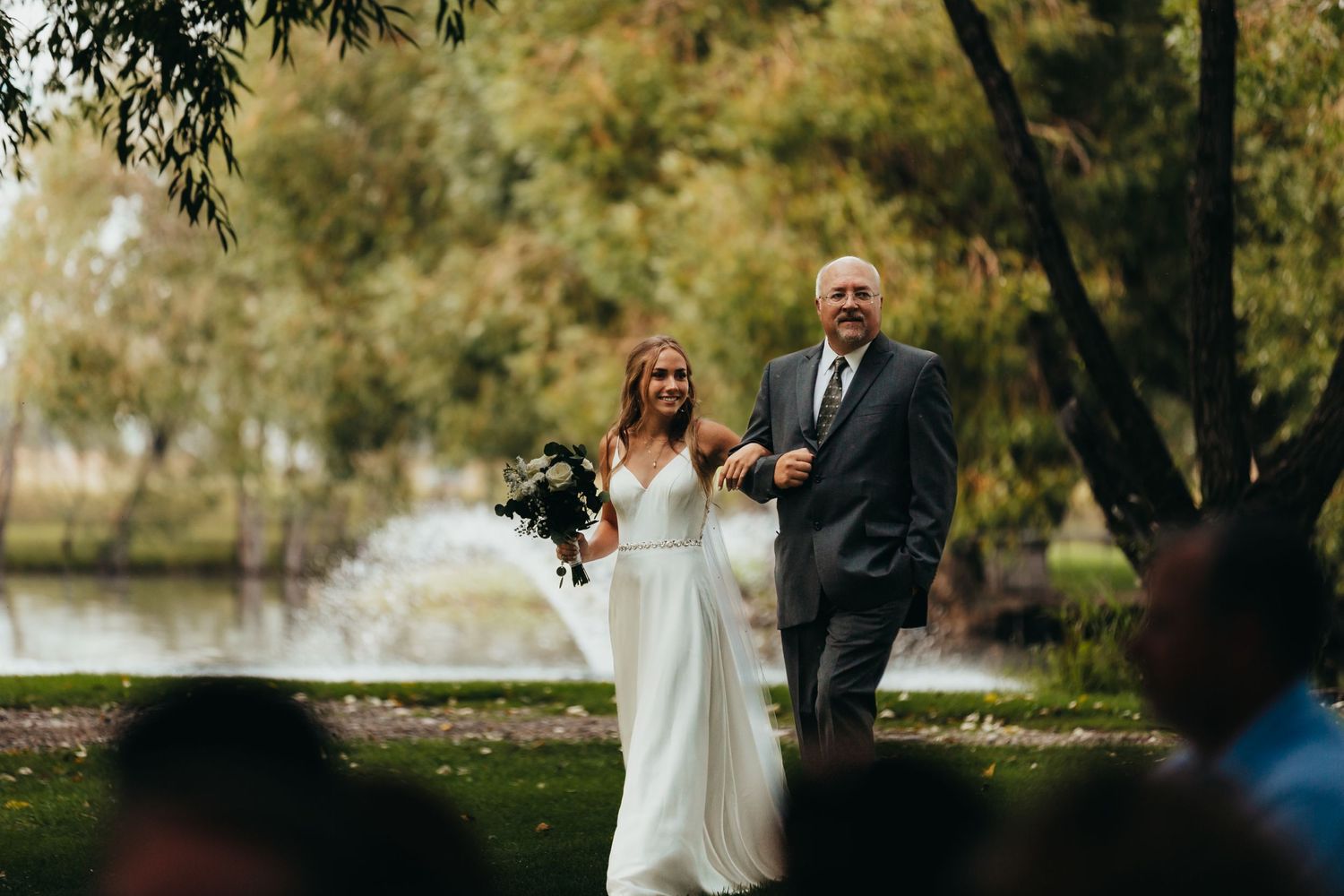 An outdoor autumn wedding ceremony with natural foliage in background.