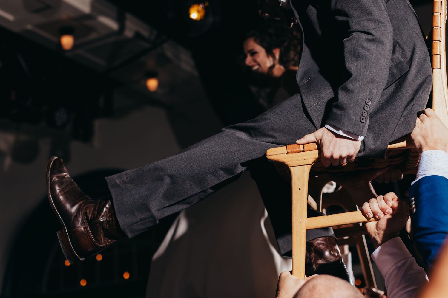 Someone's legs being lifted up during a wedding celebration dance.