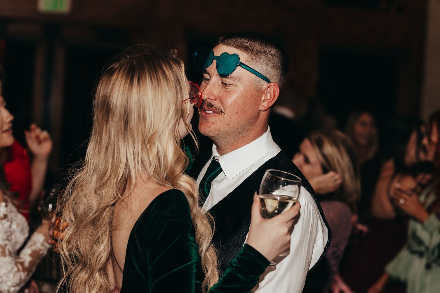 Festive party scene with guests dancing and celebrating in formal attire.