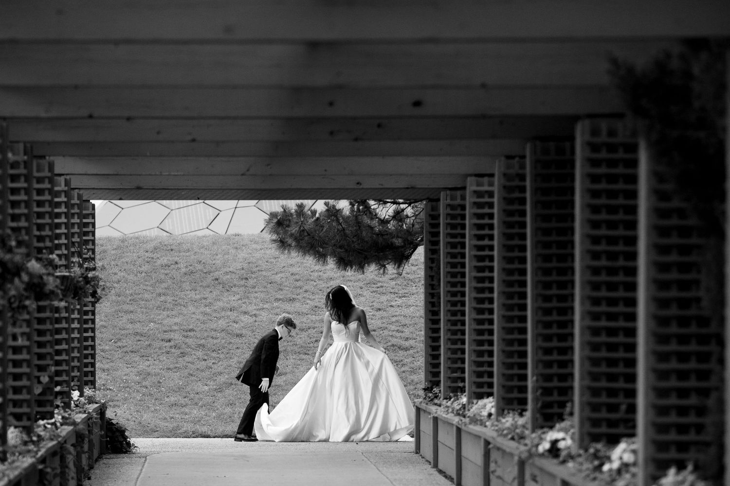 A black and white photo of a couple descending stairs with an ocean view.