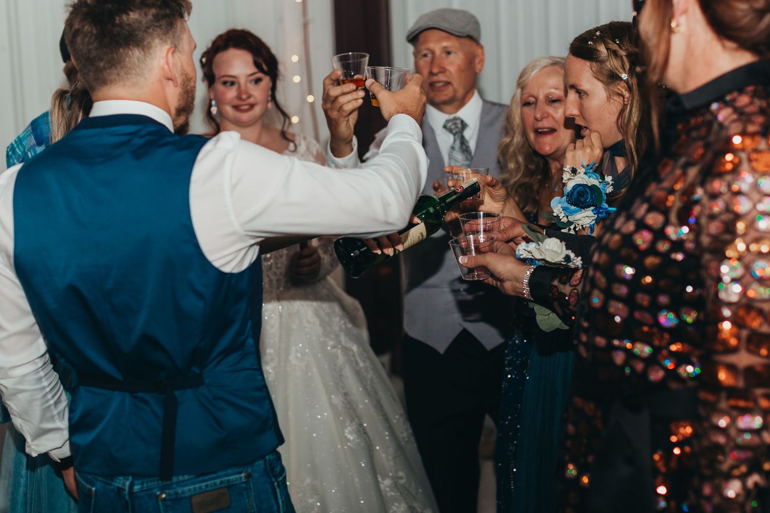 Wedding guests celebrate with champagne during a festive reception moment.