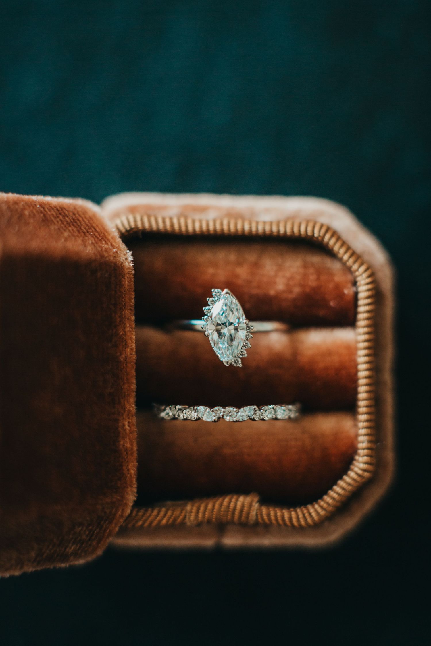 Sparkling diamond engagement ring nestled in vintage brown velvet ring box.