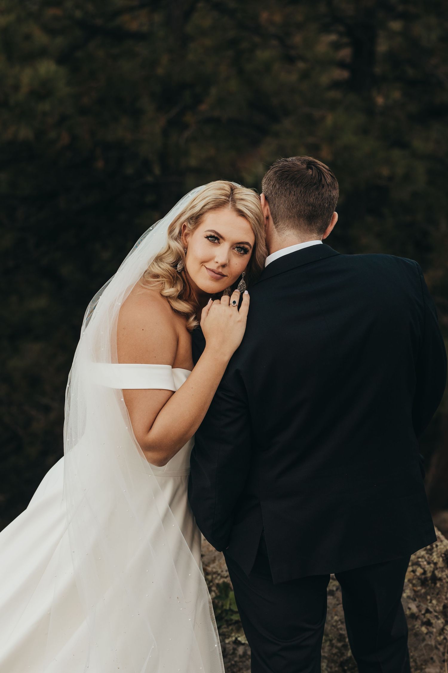 Romantic wedding portrait of newlyweds embracing outdoors.