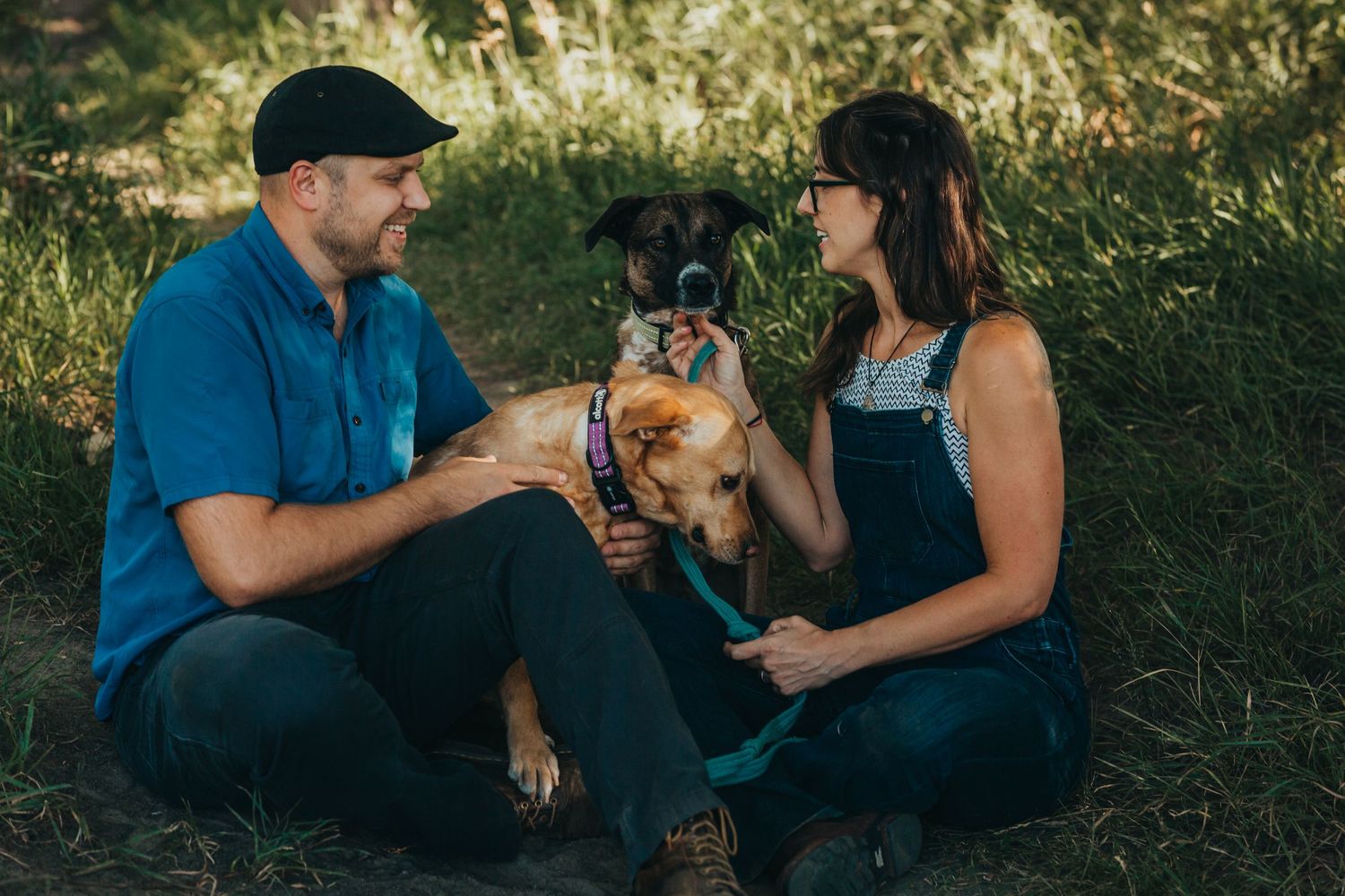 Couple sitting outdoors with their small dog on a sunny afternoon.