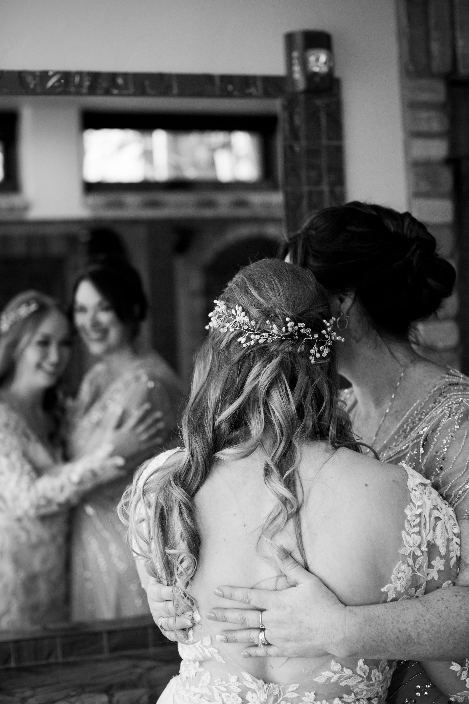 Black and white photo of women in formal dresses embracing during a celebration.