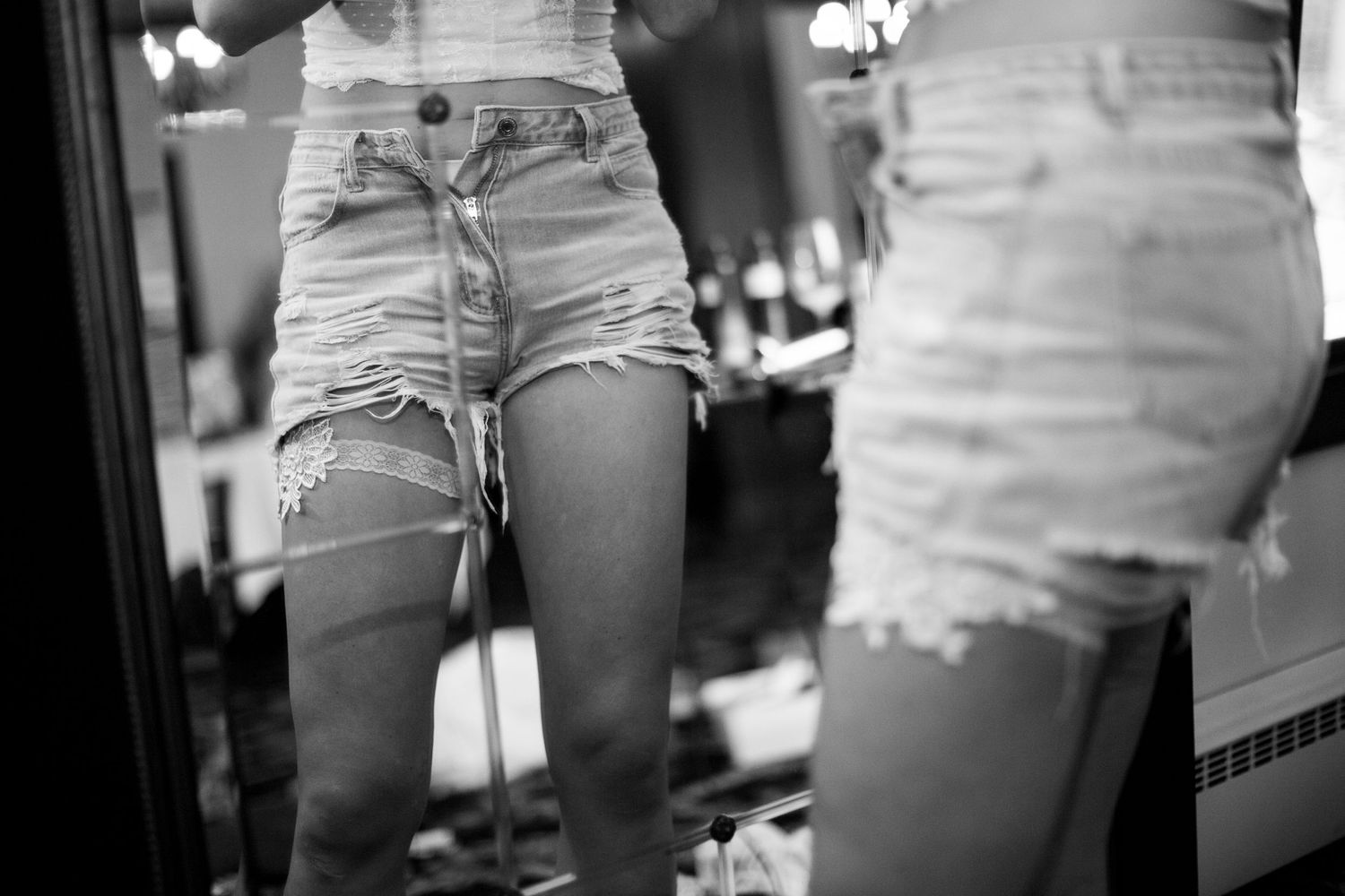 Close-up shot of distressed denim shorts in black and white.