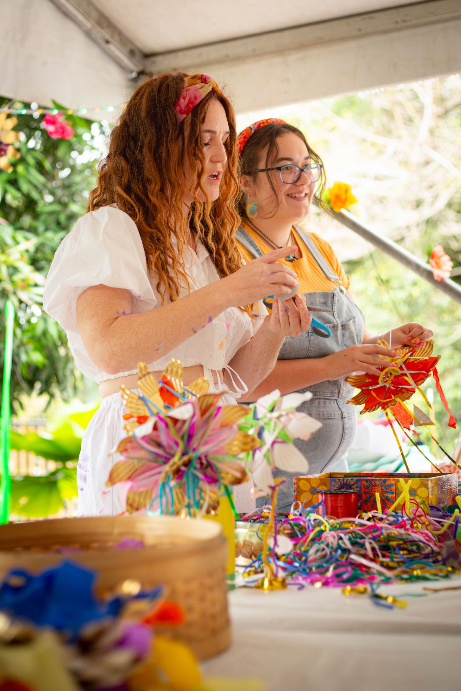 Two women smiling at an outdoor event in Rockhampton with greenery in the background