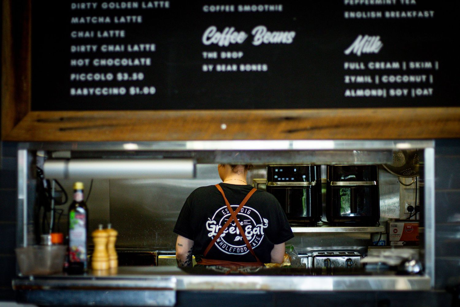 Barista preparing coffee behind the counter during a branding session at a local Rockhampton café