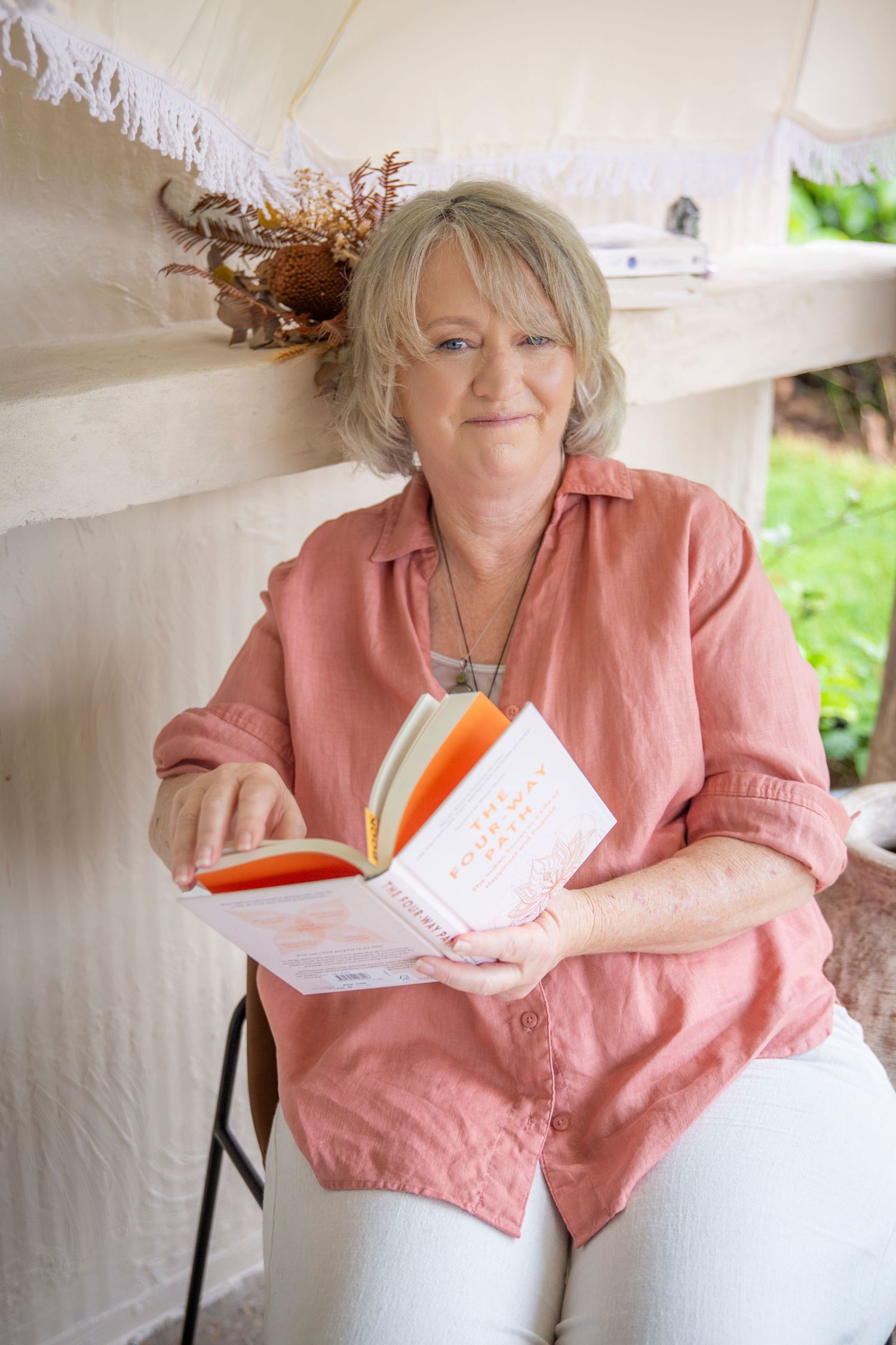 Woman in pink shirt leaning on a chair in a minimal studio headshot session in Rockhampton.