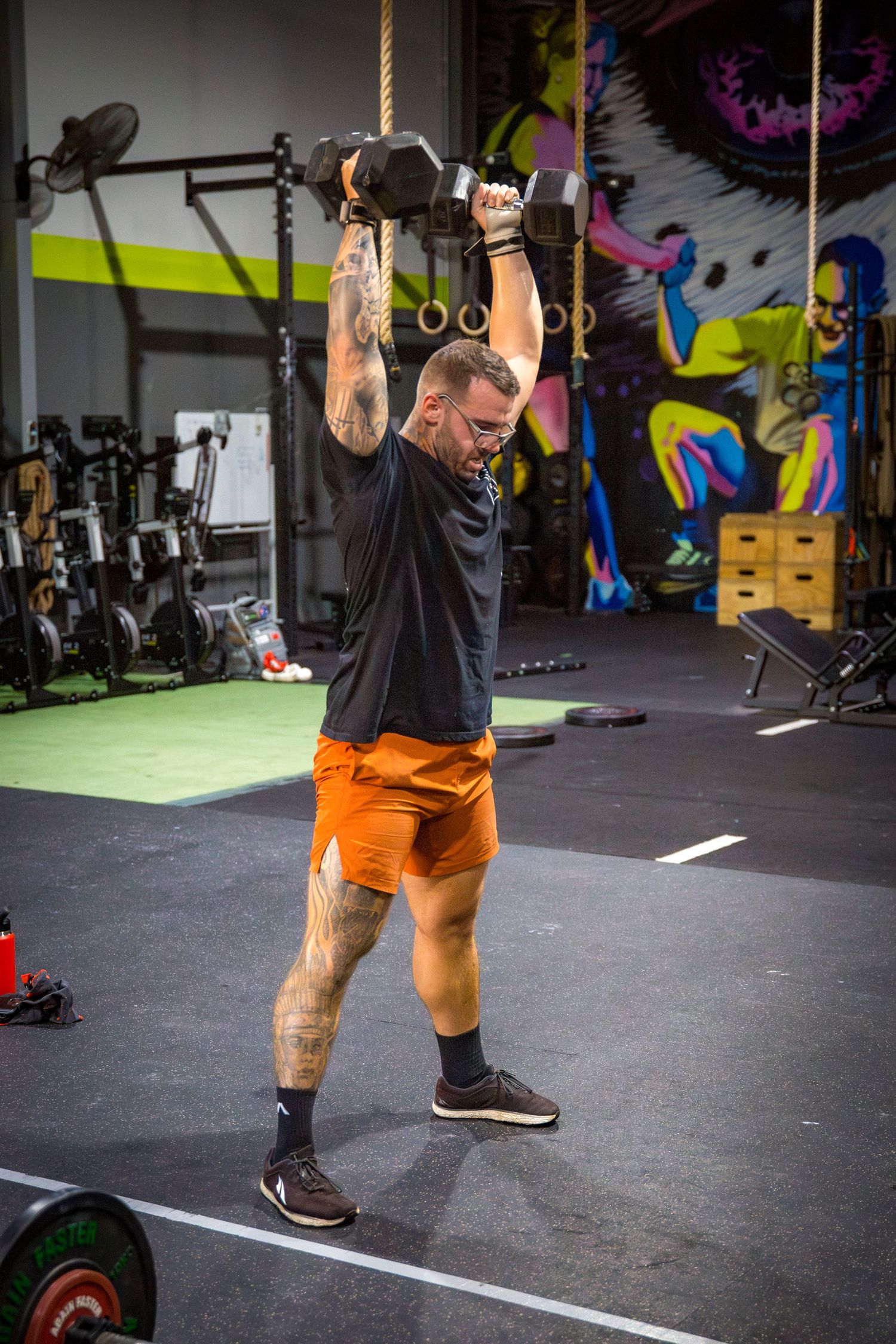 Gym members dumbbell snatch at CQ Fitness Co during high-energy workout