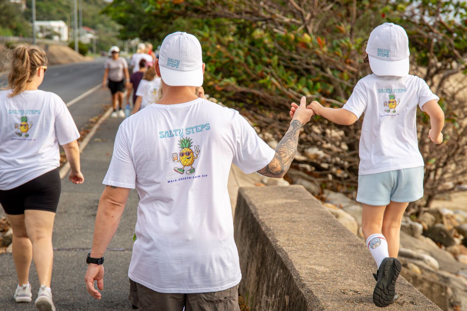 Dad and child walking with beachside view in Yeppoon