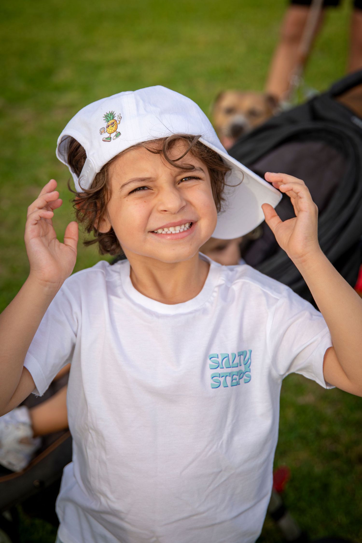 Boy smiling wearing salty steps hat and shirt at community event Yeppoon