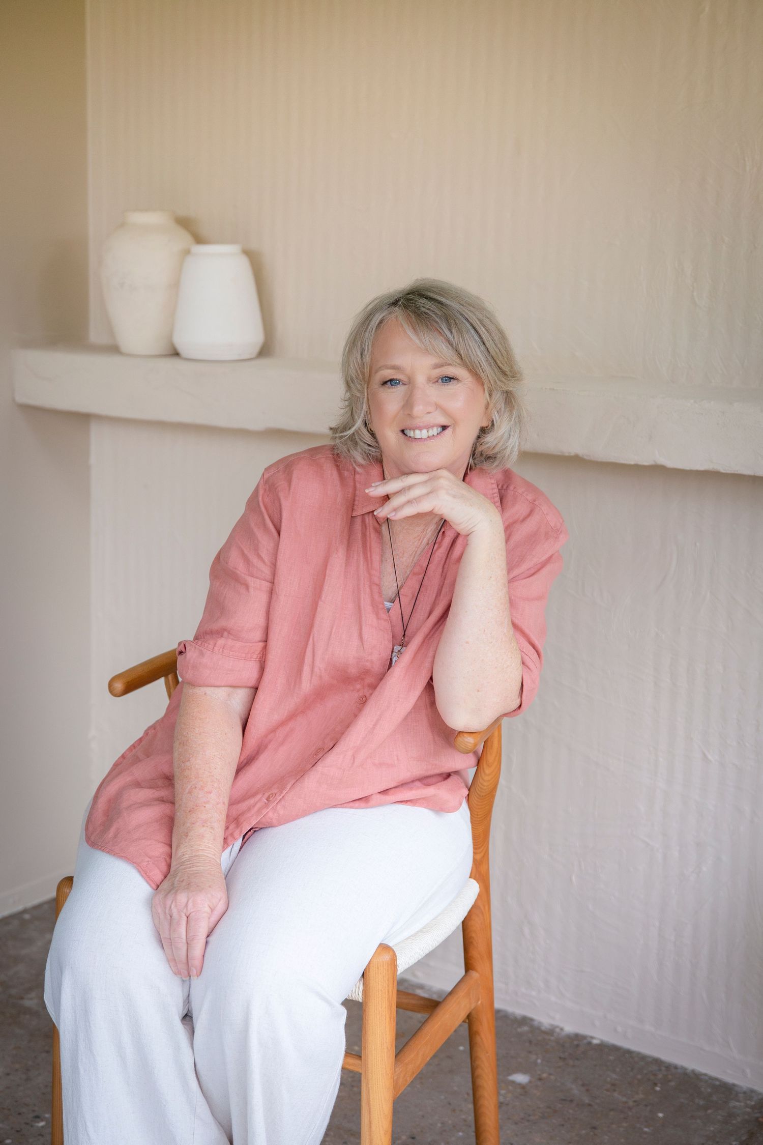 Close-up lifestyle headshot of a woman in a relaxed branding shoot, seated in soft natural light