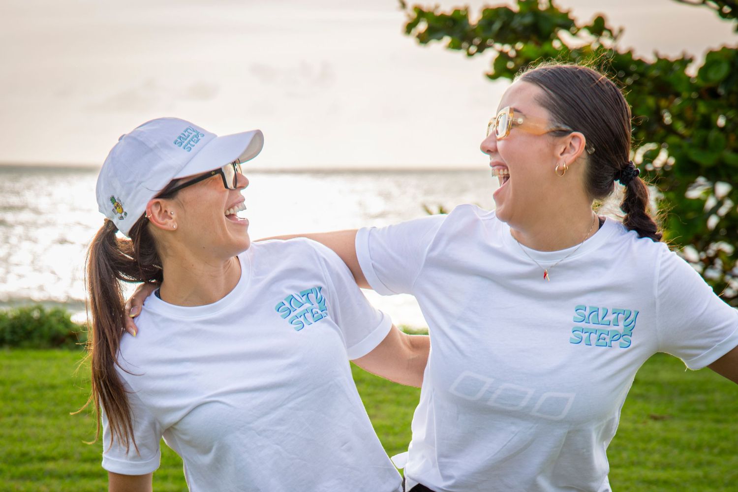 Two women smiling at each other wearing Salty Steps shirts in Yeppoon