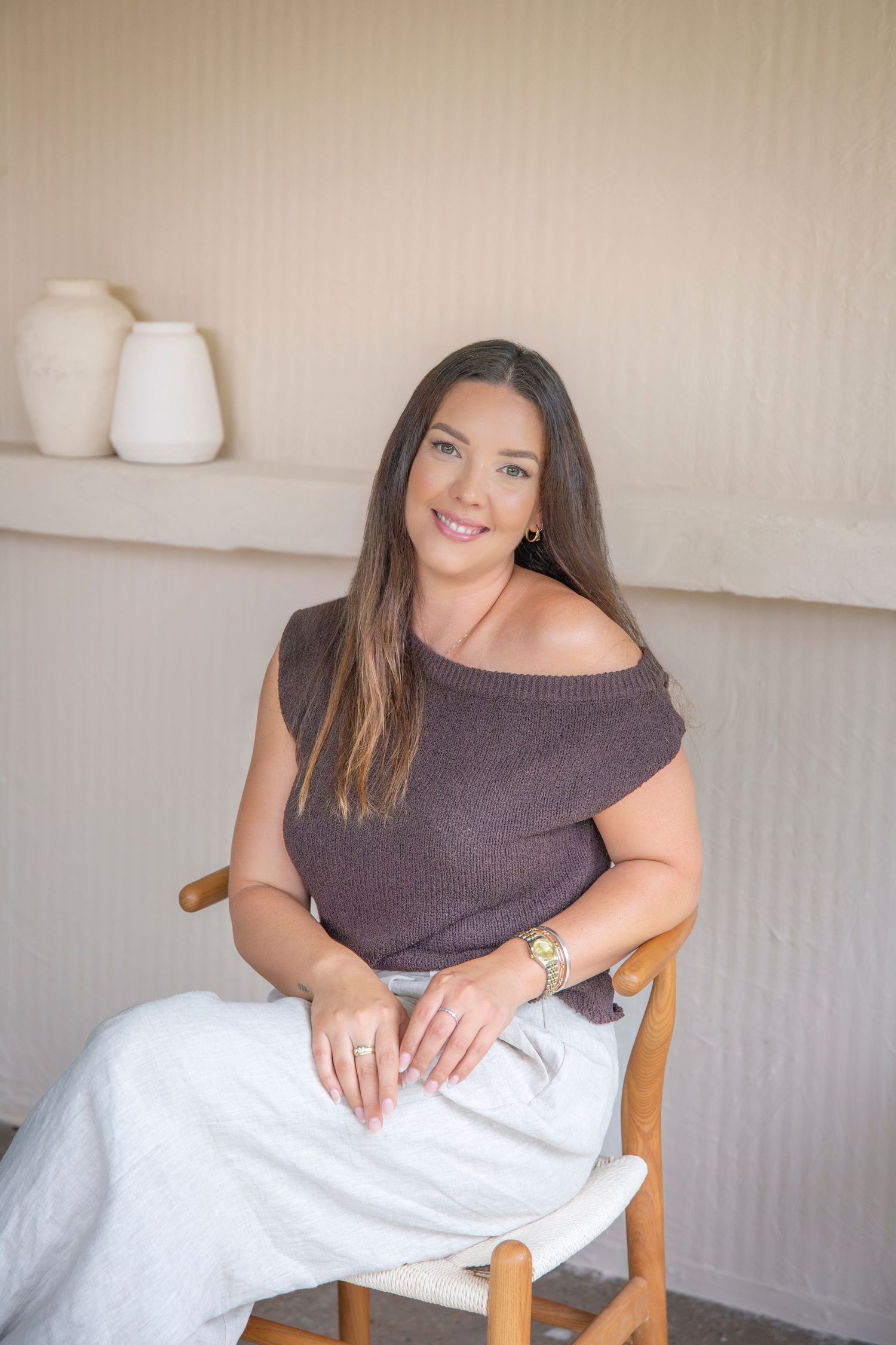 Confident headshot of a woman seated in a minimalist Rockhampton studio, captured in soft, natural light