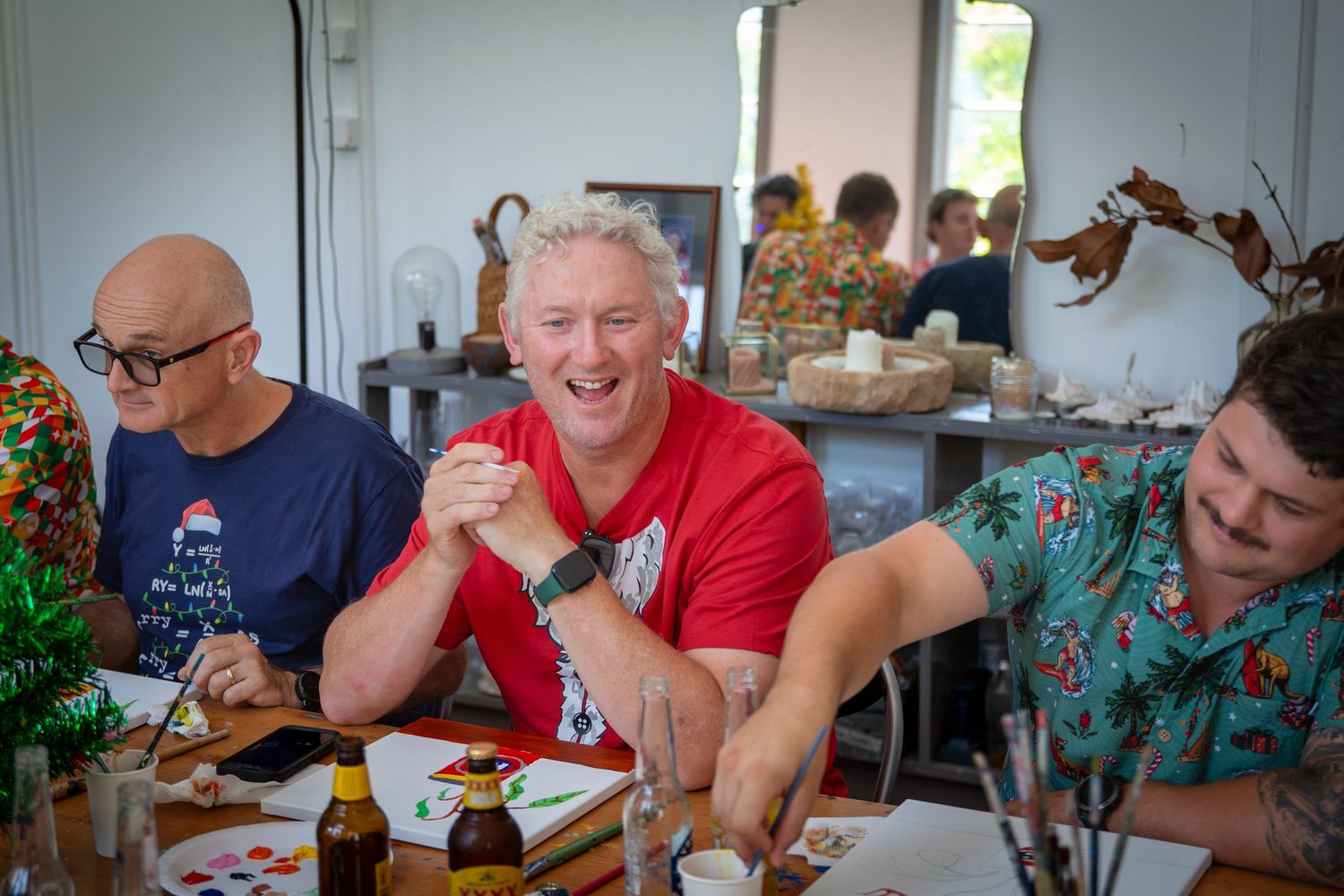 Candid photo of guests chatting at a Rockhampton Christmas party, dressed in vibrant festive shirts