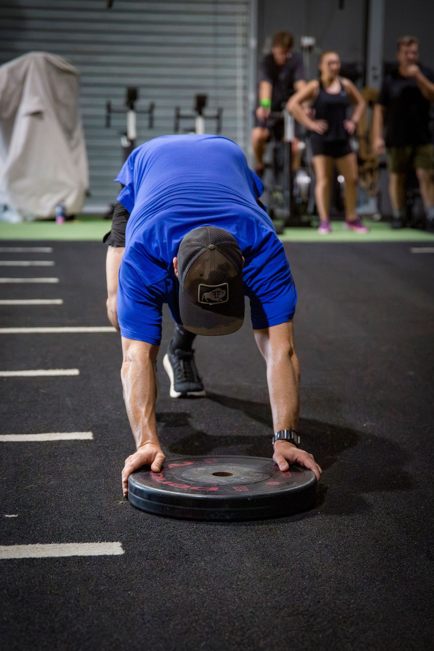Gym member plate push at CQ Fitness Co during high-energy workout